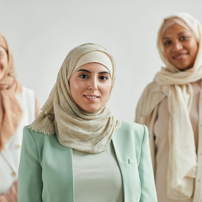 Diverse group of smiling people in a bright, modern yoga studio.