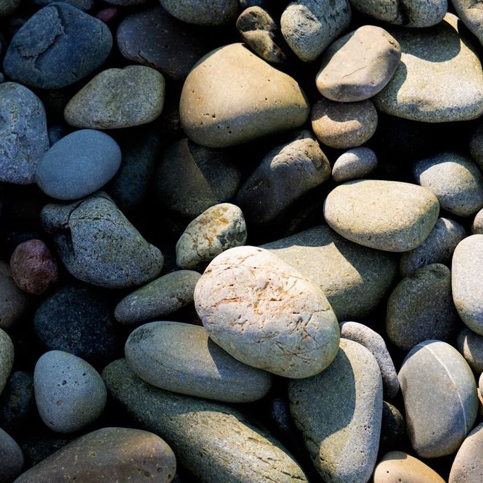 Perfectly balanced stack of smooth stones on a calm, misty background.
